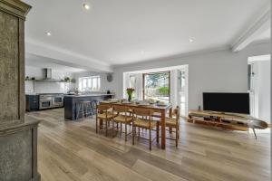 a kitchen and dining room with a table and chairs at Cedar Barn in Chichester