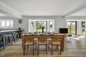 a kitchen and dining room with a table and chairs at Cedar Barn in Chichester