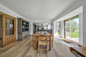 a dining room with a wooden table and chairs at Cedar Barn in Chichester +70 photos