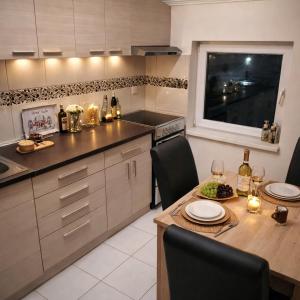 a kitchen with a table and chairs and a window at Apartman Dionis SM in Sremska Mitrovica +21 photos