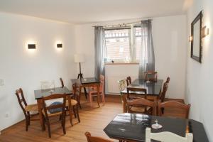 a dining room with tables and chairs and a window at Hotel Stadtherz in Burgwedel