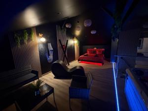 a dark room with a bed and a couch at AMORE suite de luxe & spa in Laplume