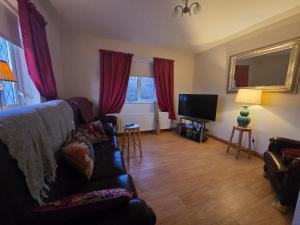 a living room with a couch and a television at Downings View in Ballynaworthra