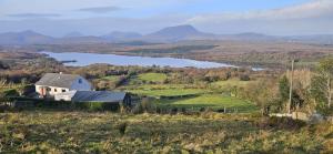 a barn on a hill with a lake in the background at Downings View in Ballynaworthra