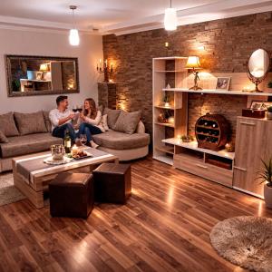a man and a woman sitting in a living room at Apartman Dionis SM in Sremska Mitrovica