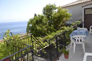a balcony with a table and chairs and the ocean at Panoramic Seaview Apartments - Koroni in Koroni