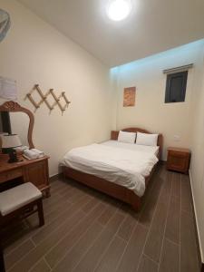 a bedroom with a bed and a chair and a desk at Rosie Hotel in Da Thien
