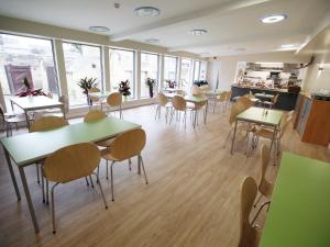 a dining room with tables and chairs and windows at YHA Alnwick - Partner in Alnwick