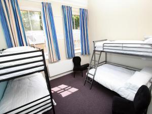 a dorm room with two bunk beds and a chair at YHA Alnwick - Partner in Alnwick +17 photos
