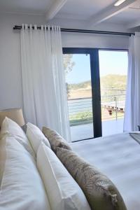 a bedroom with a bed with a large window at Chintsa Oceanfront in Chintsa