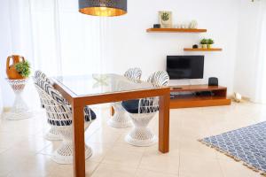 a dining room with a glass table and chairs at Avenue Apartment - Family-friendly T2 - Estacionamento Privado in Quarteira