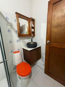 a bathroom with a toilet with a red lid and a mirror at Hotel Dulce Campestre in Jardin