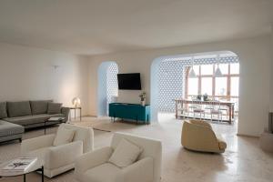 a living room with white furniture and a tv at La balza di Scilla in Scilla