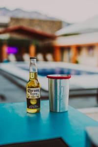 a bottle of beer next to a cup on a table at Casa Arcos Tepoztlán in Tepoztlán