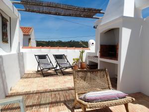 two chairs sitting on a patio with a view of the ocean at Casa Nela in Odeceixe