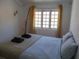 a bedroom with a bed with two towels on it at Casa Nela in Odeceixe