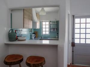 a kitchen with two wooden stools in front of a counter at Casa Nela in Odeceixe