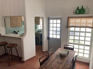 a kitchen and dining room with a wooden table and chairs at Casa Nela in Odeceixe +19 photos