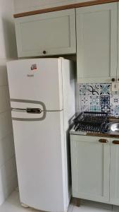 a kitchen with a white refrigerator and a stove at Lar Botticelli 2Quartos wifi piscina ArCond in Ananindeua