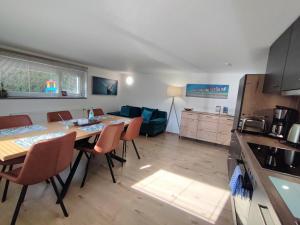a kitchen and living room with a table and chairs at FeWo Heimathafen in Bodman-Ludwigshafen