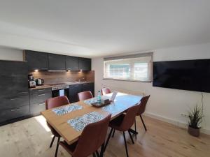 a dining room with a table and chairs and a kitchen at FeWo Heimathafen in Bodman-Ludwigshafen