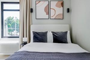 a bedroom with a bed with three pictures on the wall at Oak Suite · District 4 in Zurich