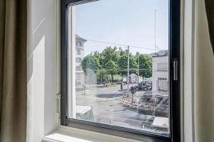 a window with a view of a city street at Oak Suite · District 4 in Zurich