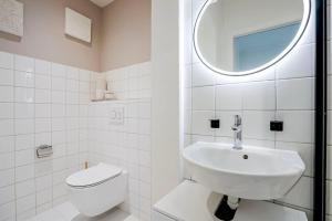 a bathroom with a sink and a toilet and a mirror at Oak Suite · District 4 in Zurich +6 photos