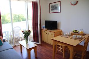 a living room with a television and a table with a table sidx sidx sidx at Oly Vacances Les Landes in Cassen