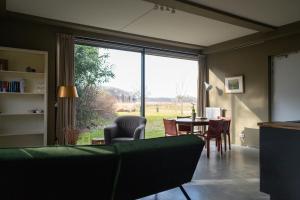 a living room with a table and a large window at Landhuis Hotel Restaurant Rikus in Eext