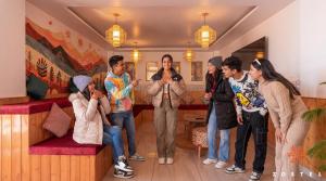 a group of people standing around in a room at Zostel Dharamkot, Bhagsu in McLeod Ganj