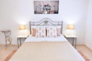 a bedroom with a bed with pillows and two lamps at Avenue Apartment - Family-friendly T2 - Estacionamento Privado in Quarteira