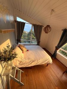 a bedroom with a bed in a room with a window at Refugio Urbano Melipulli in Puerto Montt