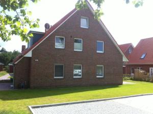 a red brick house with white windows and green grass at kleiner-Fiete in Wittdün