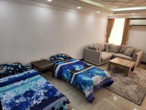 a living room with two beds and a couch at Shahan Residence in Muscat