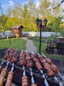 a grill with several skewers of meat on it at Elit BonRe in Romny