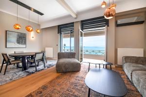 a living room with a table and a couch at ICONIC LEGACY Suite seafront in Thessaloniki