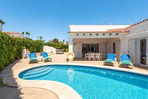 a swimming pool with blue chairs and a house at Villa Mencia by Villa Plus in S'Algar