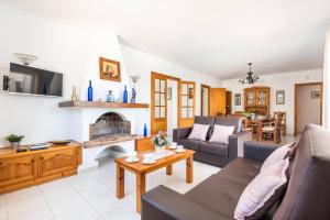 a living room with a couch and a fireplace at Villa Mencia by Villa Plus in S'Algar