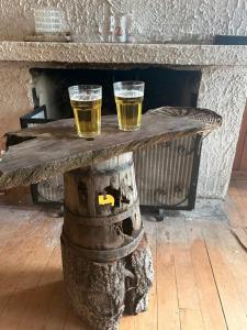 two glasses of beer sitting on top of a wooden table at Refugio Urbano Melipulli in Puerto Montt