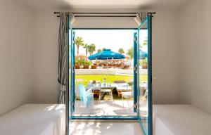 a bedroom with a door open to a patio with a table and chairs at Mitsis Norida in Kardamaina +66 photos