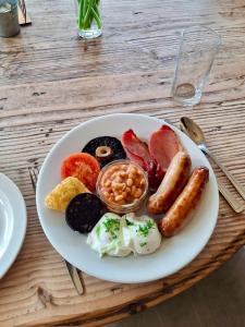 a plate of breakfast food on a wooden table at Nant Gwrtheyrn in Llithfaen