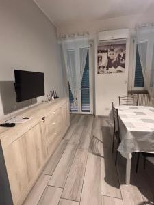 a living room with a television and a dining table at Carlotta 5 in Biella