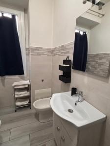 a bathroom with a sink and a toilet and a mirror at Carlotta 5 in Biella
