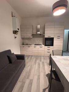 a living room with a couch and a kitchen at Carlotta 5 in Biella