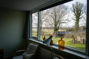 a window with bottles and a laptop on a table at Landhuis Hotel Restaurant Rikus in Eext +7 photos