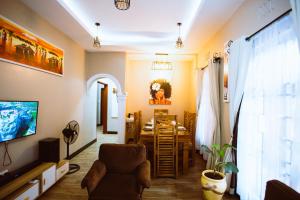 a living room with a chair and a dining room at Tunji Homestay in Arusha