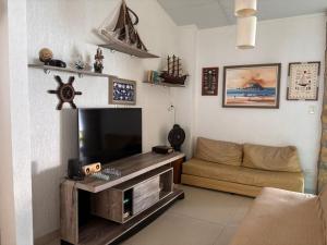a living room with a television and a couch at Angra dos reis Serra e Mar in Angra dos Reis