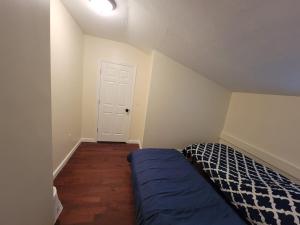 a bedroom with a bed with a blue comforter at Esjacpe Guest House 2 in Boston