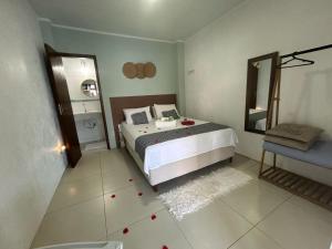 a bedroom with a bed and a bathroom with a mirror at Angra dos reis Serra e Mar in Angra dos Reis +17 photos